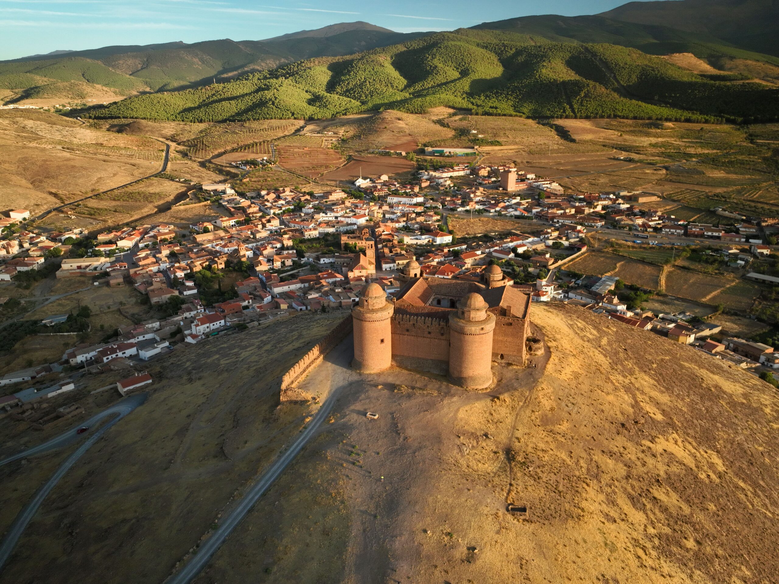 Drone shot of Castillo de La Calahorra overlooking the town and surrounding landscape in Spain.
