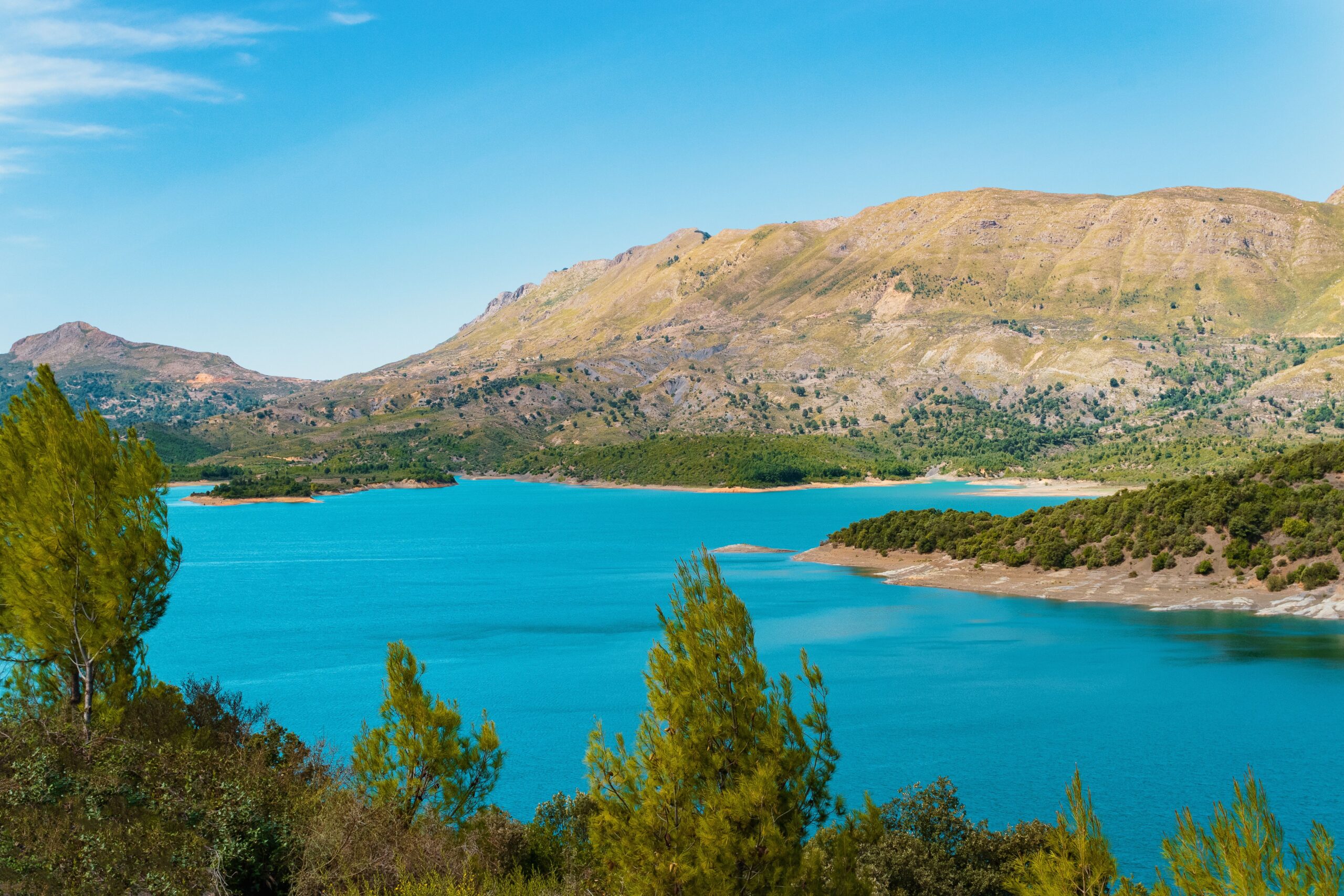 Beautiful lake surrounded by mountains under a clear blue sky, perfect for nature lovers.
